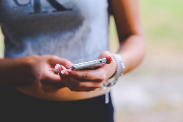 A woman holding her cell phone in both hands.